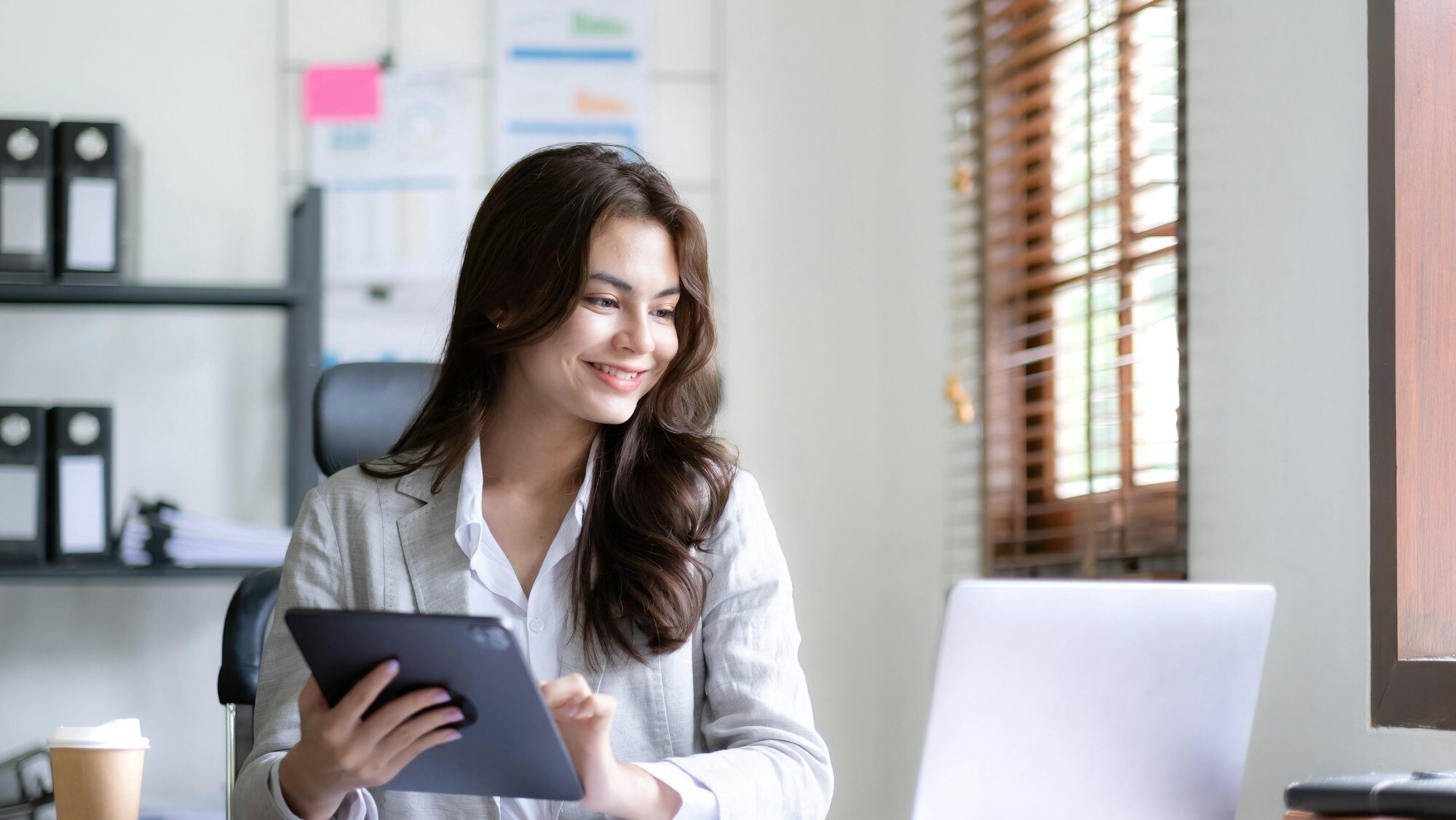 Asian Business woman using calculator and laptop for doing math finance on an office desk, tax