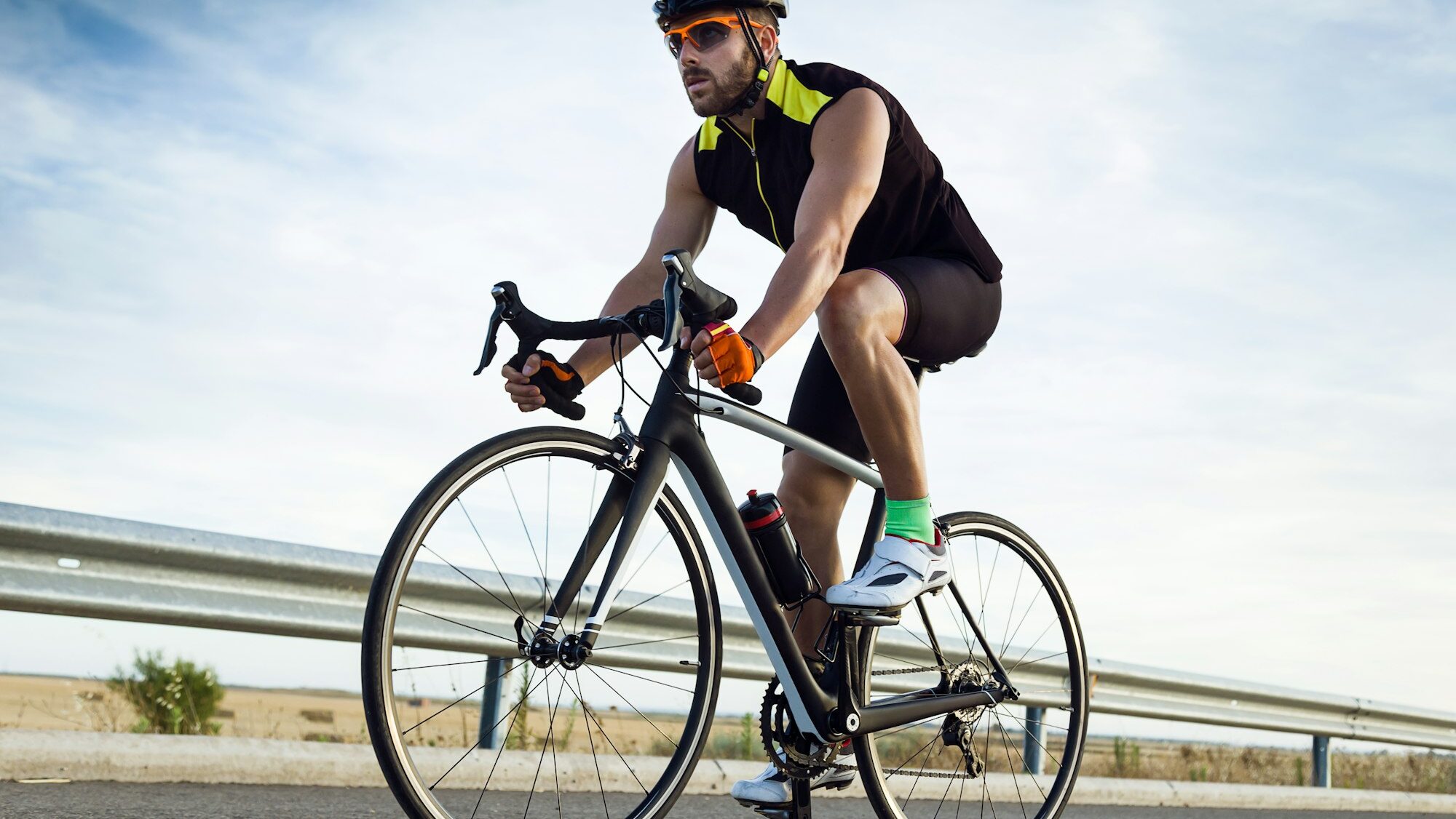 Handsome young man cycling on the road.